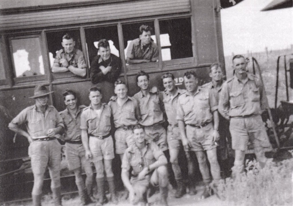 Some of C Coy (mostly No 9 Pln) in transit Rear L-R Kev Moir, Clarrie Henderson, Fred Webb Standing, Taffy Jones, Cyril Anderson, Jock Leith, Chris Mc Lennan, Les Marriot, Ern Ricketts, Paddy Byrne. Kneeling Harry Norris 